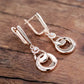Boucles d'oreilles pendantes anneaux enlacés, bijou en plaqué or rose et en zircons naturels